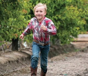 David Muxlow, part of a future generation of Family Tree Farms growers, runs to his father, Andy, in Reedley, California on April 9, 2015. (TJ Mullinax/Good Fruit Grower)