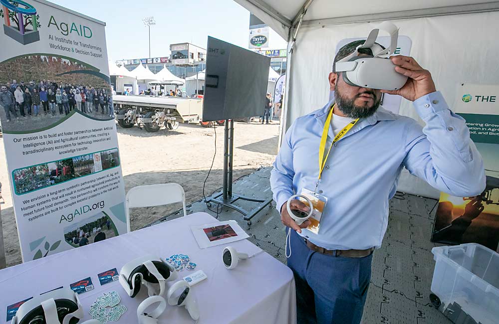 The FIRA trade show included educational programs, such as Washington State University’s AgAID booth where Junior Gomez, a student recruitment coordinator, set up Meta Quest virtual reality headsets. (TJ Mullinax/Good Fruit Grower)