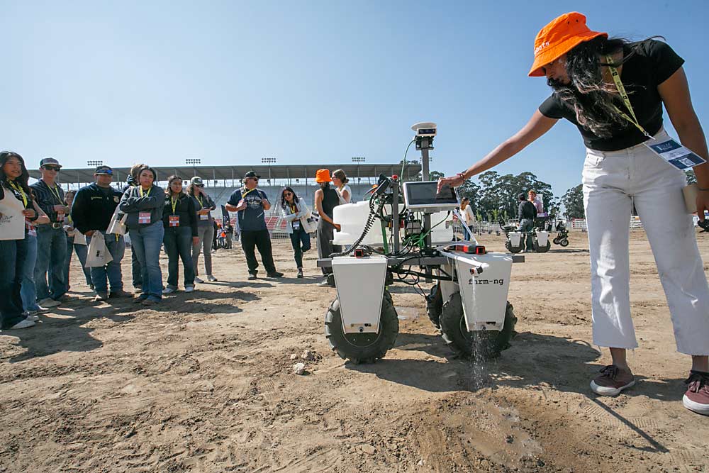 Riya Desai, an undergraduate researcher at University of California, Davis, shows FFA students a robotic vehicle developed by ag AI company farm-ng at the FIRA USA trade show in September in Salinas. (TJ Mullinax/Good Fruit Grower)