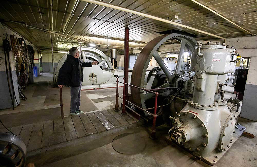 Bud Hollingbery from Hollingbery and Son shows some of the large generators and compressors that made ice within the bowels of the J.M. Perry fruit storage and icehouse building. These machines created large volumes of ice that were vital to the cold train system that transported apples from Fruit Row across the nation. Ice was made and transported through underground tunnels to many of the fruit warehouses along the tracks. “These old buildings still have a long life,” Hollingbery said. “With proper maintenance they can be as good as new ones.” (TJ Mullinax/Good Fruit Grower)