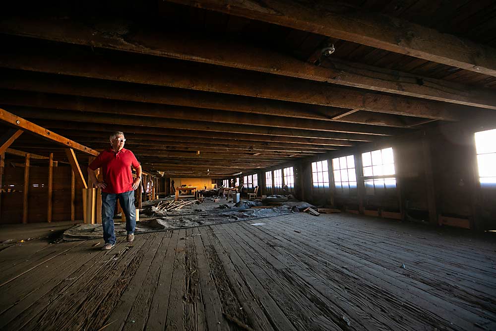 John Baule looks out of the former Helliesen Lumber and Supply Co. building windows toward the former J.M. Perry and Co. ice house along the railroad tracks near Fruit Row. Baule, curator at the Yakima Valley Museum, said companies such as the lumber company and ice-making facilities were key supporters of the early tree fruit industry. (TJ Mullinax/Good Fruit Grower)