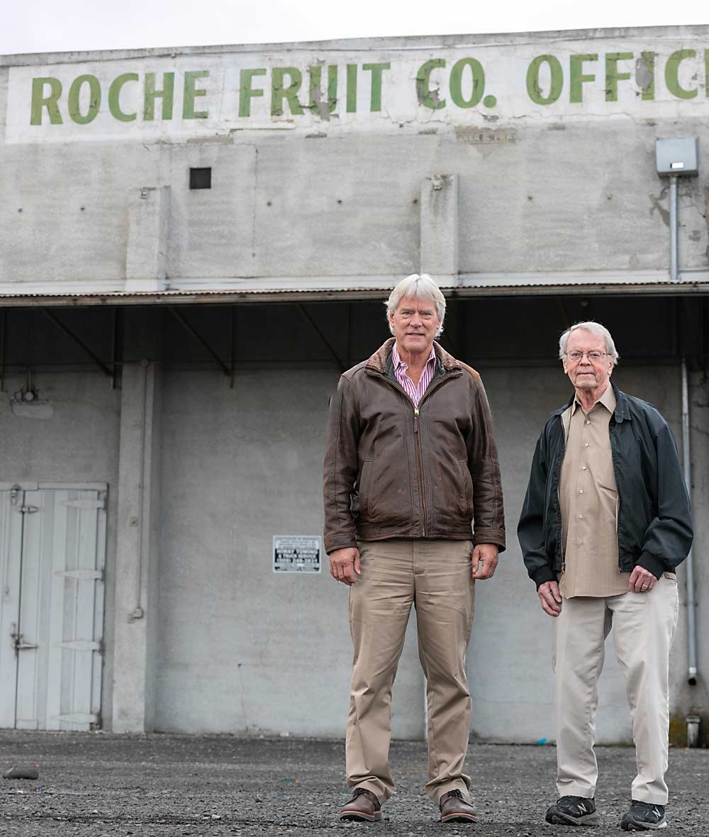 Rick Plath, left, and Jack Bloxom of Washington Fruit and Produce Co. in front of the rail-yard side of Roche Fruit, the only packing company still operating in Fruit Row. Once neighbors, Roche Fruit purchased many of Washington Fruit’s downtown buildings when it left for a new location. (TJ Mullinax/Good Fruit Grower)