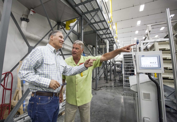 Washington Governor Jay Inslee, left, is given a tour of a new cherry packing line at Washington Fruit and Produce Co. by company president Rick Plath on June 6, 2014, in Yakima, Washington. The state-of-the-art cherry line was in its third full day of operation. (TJ Mullinax/Good Fruit Grower)