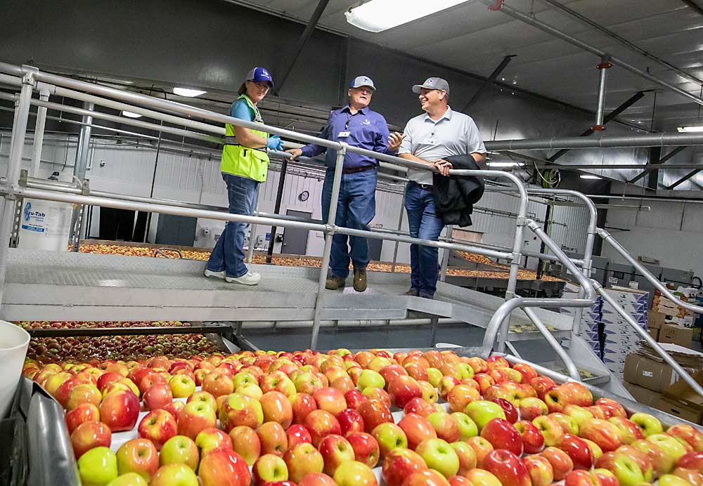 Robinson discusses a run of Honeycrisp apples in September with Bridget Pershall, left, and Derek Allred at the Double Diamond packing facility in Quincy. (TJ Mullinax/Good Fruit Grower)