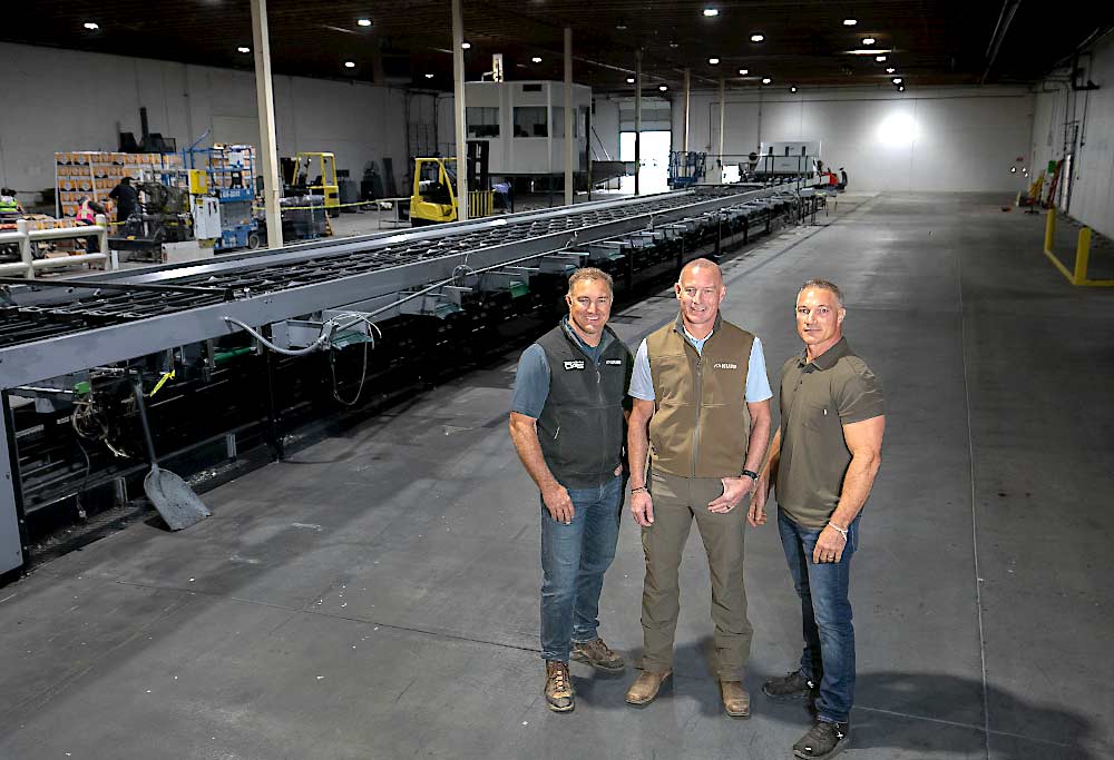 Brothers John, David and Pete Douglas, left to right, co-owners of Douglas Fruit of Pasco, Washington, stand in the space that will house their new, state-of-the-art stone fruit packing line, which they will install this winter after the old line is fully removed. (TJ Mullinax/Good Fruit Grower)