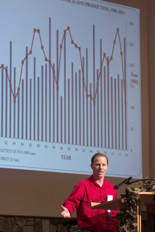 Trent Ball gives the annual “State of the Grapes” report during the Washington State Grape Society’s annual meeting in 2014. Ball talked about how Concord prices (in chart noted in red) were down, in contrast to the big crop size (in chart in blue.) (TJ Mullinax/Good Fruit Grower)