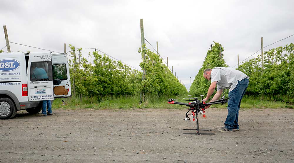 Cody Bounds, a G.S. Long drone operator, loads a mixture of lacewing eggs and larvae for aerial release in June in an organic apple orchard near Mattawa, Washington. Drones still evoke a lot of imagination, but beneficial insect release is one arena where the technology has penetrated the tree fruit market. (TJ Mullinax/Good Fruit Grower)