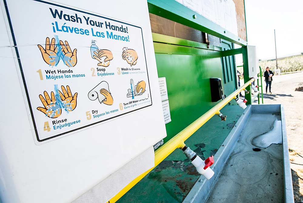 A mobile handwashing station awaits use in a Grandview, Washington, orchard in 2019. Now that the coronavirus is a known workplace hazard, safety authorities throughout the country are enforcing measures to protect workers from it, such as numerous and well-equipped handwashing stations on each farm. (TJ Mullinax/Good Fruit Grower)