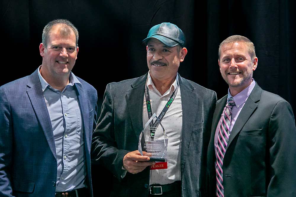 Honored for his long career in the Washington tree fruit industry, Ofelio Borges, center, receives the Latino Leadership Award presented by Mark Hambelton, left, and Marty Olsen, right. (TJ Mullinax/Good Fruit Grower)