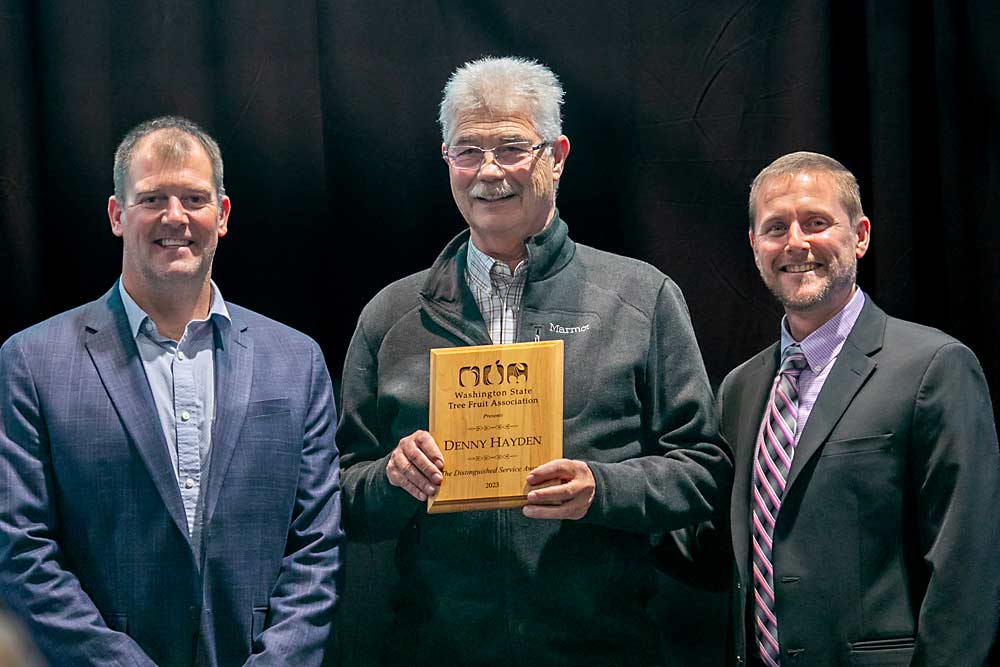 Longtime cherry grower Denny Hayden, center, accepts the Washington Tree Fruit Distinguished Service Award with Mark Hambelton, left, and Marty Olsen, right. (TJ Mullinax/Good Fruit Grower)