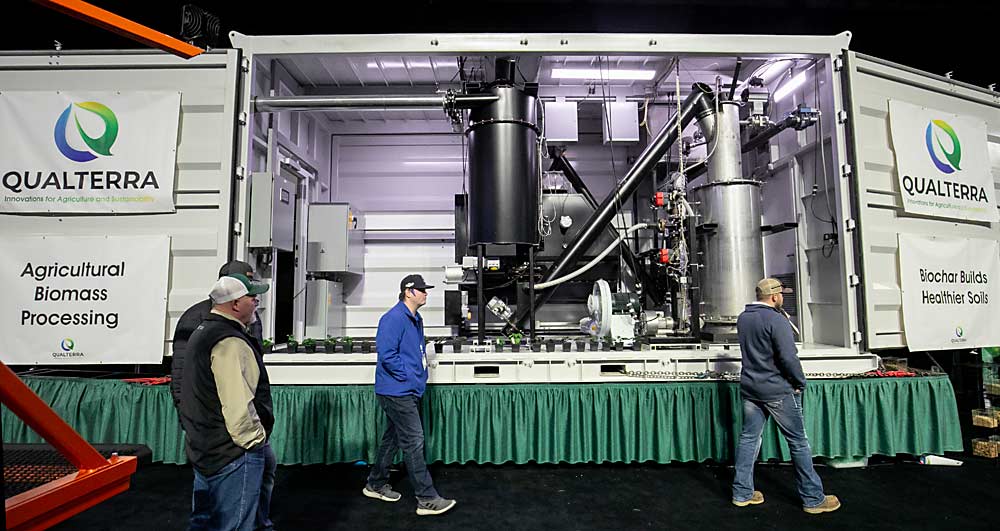 Qualterra displays one of its biomass processing units during the NW Hort Expo in Wenatchee, Washington, in December.  The system can process different agricultural waste, from wheat straw to wood chips, into green synthetic gas and biochar for use as a soil amendment.  (TJ Mullinax/Good Fruit Grower)
