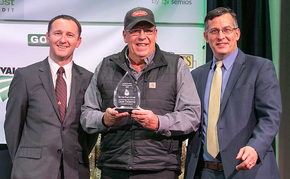 Jordan Matson, left, and Jared England, right, present the Silver Pear Award to Geoff Thornton during the 2022 Washington State Tree Fruit Association Annual Meeting on Dec. 6 in Wenatchee, Washington. (TJ Mullinax/Good Fruit Grower)