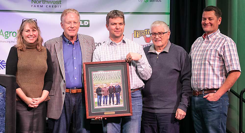 Shannon Dininny, far left, presents the Good Fruit Grower of the Year Award to the McDougall family — from left: Scott, Bryon, Stuart and Matt — during the 2022 Washington State Tree Fruit Association Annual Meeting on Dec. 6 in Wenatchee, Washington. (TJ Mullinax/Good Fruit Grower)