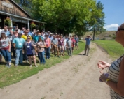 The old Okanagan post office in Spallumcheen, British Columbia, was the perfect setting for 2018 International Fruit Tree Association summer tour group photo as LauraLee Heuser Gale, right, gives an announcement in the hot afternoon sun on July 24. (TJ Mullinax/Good Fruit Grower)