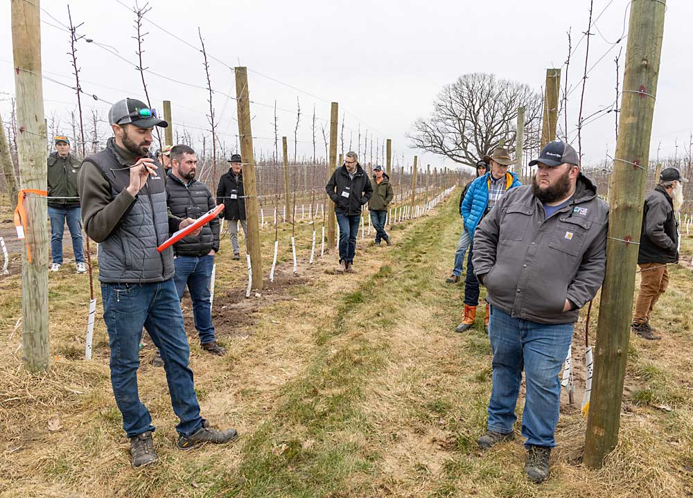 Tye Wittenbach, left, manager of LTI Ag Research, discusses some of the company’s research trials during the IFTA tour of Michigan’s Fruit Ridge. (Matt Milkovich/Good Fruit Grower)
