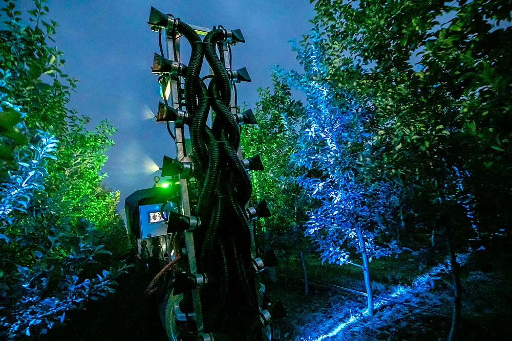 The AgBot autonomous sprayer developed by Dutch companies AgXeed and Hol Spraying Systems demonstrates its precision spray system after dark, actively turning nozzles on and off depending on tree canopy, which it detects with a chlorophyll fluorescence sensor, during the 2023 International Fruit Tree Association summer educational tour at Crisp Growers’ farm in Nova Scotia, Canada, in July. (TJ Mullinax/Good Fruit Grower)