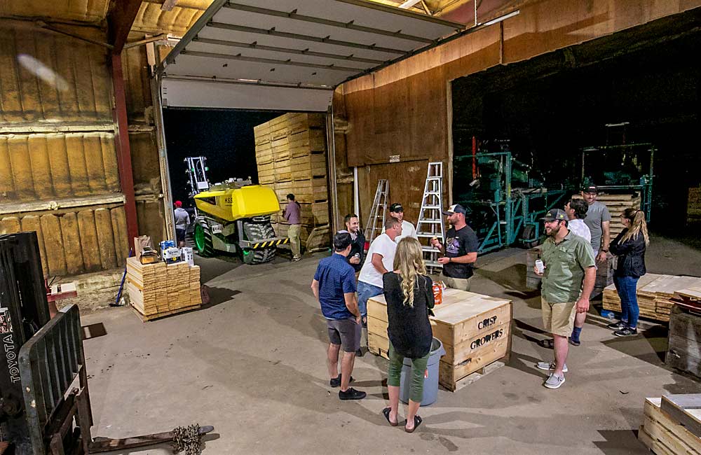 IFTA members socialize after a night demonstration of an AgBot sprayer at Crisp Growers. While not an official part of the tour, off-schedule opportunities to learn from others are a big part of the IFTA experience. (TJ Mullinax/Good Fruit Grower)