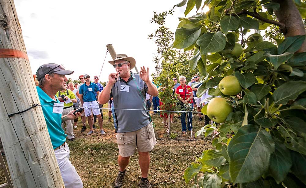 Grower Tom Ferri, at left, talks with Rod Farrow about how he uses precision crop load management to get 50 bins per acre of premium Honeycrisp, targeting large fruit for boutique markets. (TJ Mullinax/Good Fruit Grower)