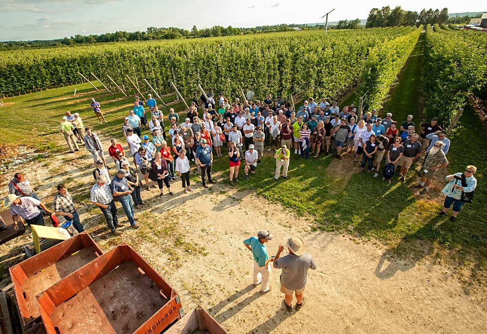 Ferri and Farrow, past International Fruit Tree Association president, talk to tour attendees about making precision crop load management pay off. (TJ Mullinax/Good Fruit Grower)