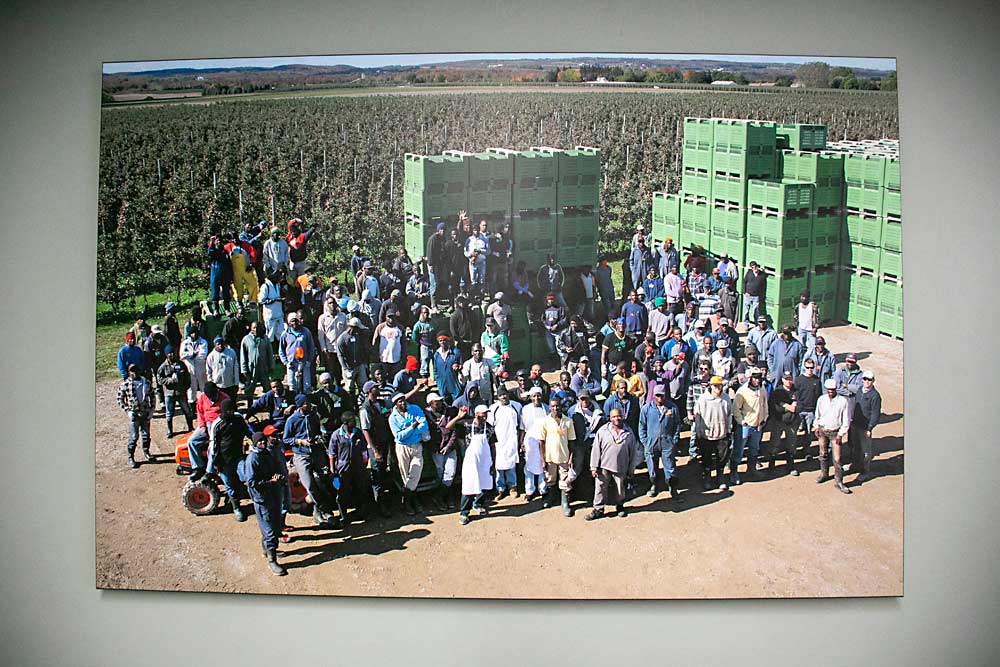 A portrait of Botden Orchards’ Jamaican farmworker crew hangs in the farm’s two-story worker housing facility in Thornbury, Ontario. Many career farmworkers return to the same farms year after year. (TJ Mullinax/Good Fruit Grower)