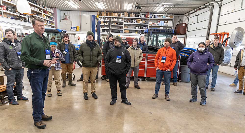 Grower David Slaybaugh, left, shows off his farm’s equipment shop and repair facility, used to fix farm equipment such as the orchard leaf blower seen at right in the background. (Matt Milkovich/Good Fruit Grower)