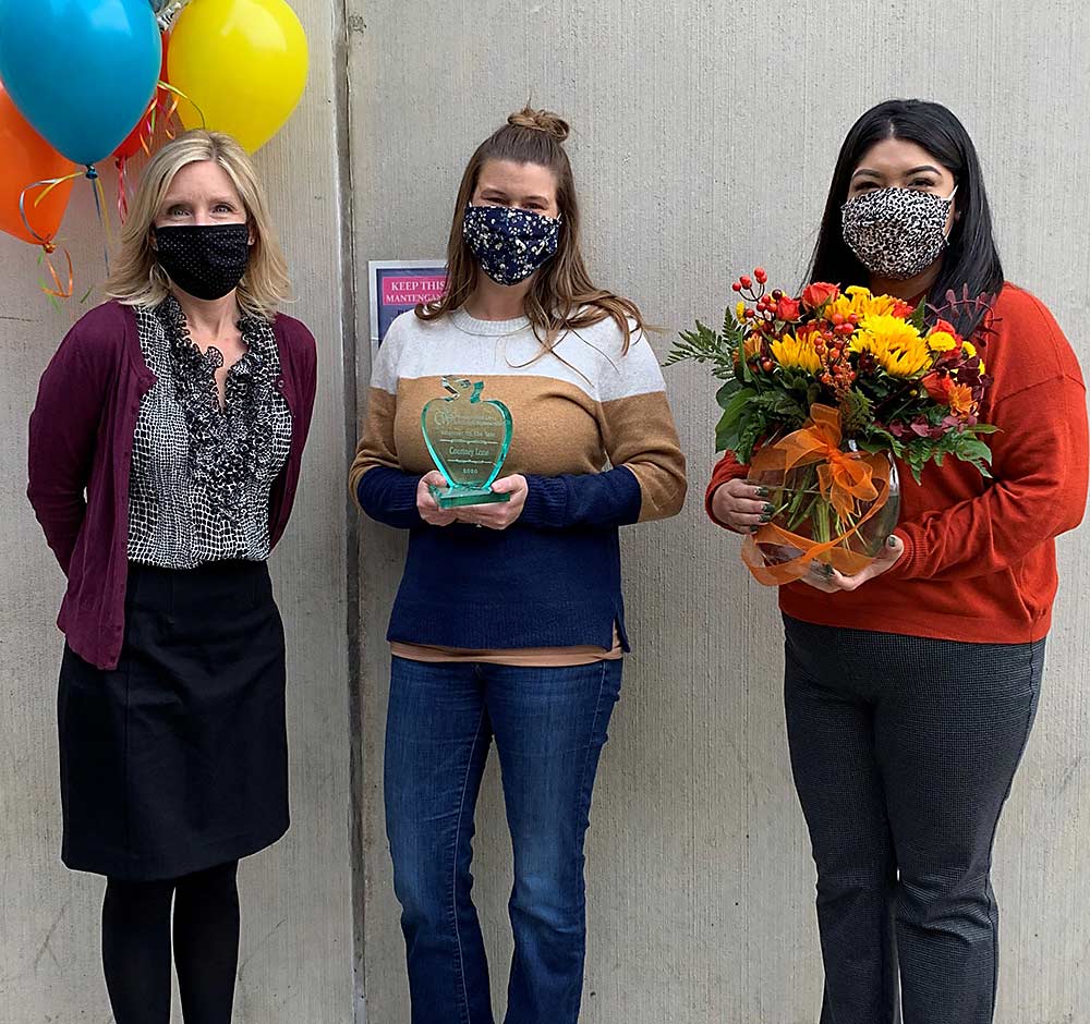 Courtney Lane, center, receives the Washington Apple Education Foundation's 2020 Individual Volunteer of the Year Award. At left is Jennifer Witherbee, WAEF executive director; at right is Xochitl Velazquez, WAEF assistant director. (Courtesy WAEF)