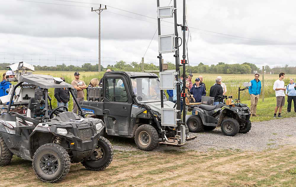 From left to right, computer vision technology companies Green Atlas, Moog and Vivid Machines displayed their vehicle-mounted equipment at Fish Creek Orchards in Albion, New York, on Aug. 9, during the annual summer tour conducted by Cornell Cooperative Extension’s Lake Ontario Fruit Program.(Matt Milkovich/Good Fruit Grower)