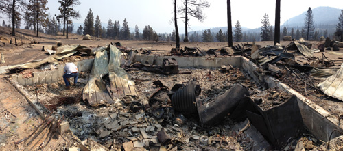 Loren Dolge searches for personal items in the ashes of his burned home outside of Brewster, Washington on July 21, 2014. (Courtesy Travis Dolge) 