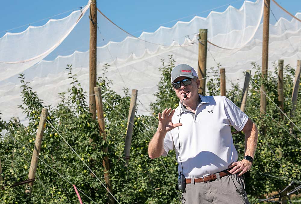 Scott McDougall, co-owner of McDougall and Sons, talks about the challenges facing the Washington apple industry, while standing in front of a block of Premier Honeycrisp where retractable netting helps to strike a balance between sun protection and color development. (TJ Mullinax/Good Fruit Grower)