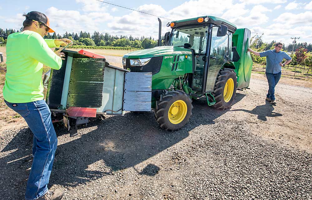 Research technician David King, left, repairs a shield on the applicator (which is tipped vertically for the repair) that bent when he and OSU weed scientist Marcelo Moretti tried to run the Zasso Electroherb weed control technology through a narrow blueberry block. Powered by the tractor’s power take-off, the technology includes a generator, high-voltage transformer in the back and front applicators on either side that direct electrical discharge into weeds by creating a closed circuit from the front of the applicator to the back through contact with the soil. (TJ Mullinax/Good Fruit Grower)