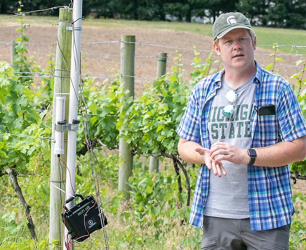 Michigan State University small fruit pathologist Tim Miles stands next to a spore trap at MSU’s Southwest Michigan Research and Extension Center in June. Miles is studying how spore traps could help detect fungal diseases in Michigan vineyards. (TJ Mullinax/Good Fruit Grower)