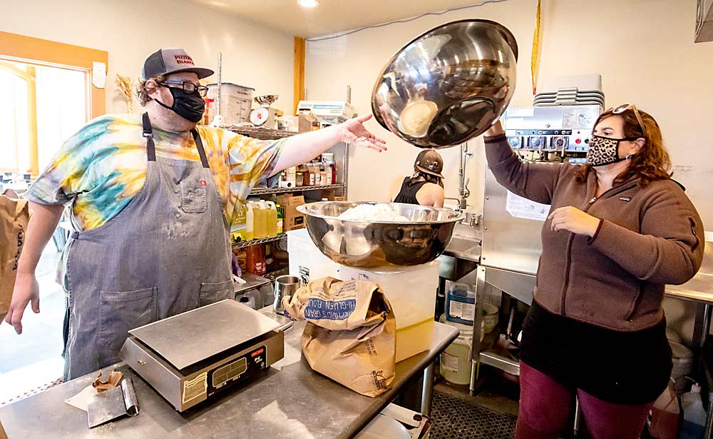 Ryan McAlexander reaches for a bowl from his sister, Trina, during pizza dough preparation at Mt. View Orchards pizzeria. Adding businesses to the farm, such as the pizzeria, creates more opportunity for the family to work together. (TJ Mullinax/Good Fruit Grower)