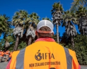 Justin Wiggs, from Wenatchee, Washington, looks out at one of Waima Orchard’s unique orchard hedgerows, filled with mature palm trees, citrus and other tropical plants during the IFTA New Zealand Study Tour on February 24, 2018, in the Hawke's Bay area. Wiggs along with every attendee was asked to wear orange hi-vis vests when touring each farm in New Zealand. (TJ Mullinax/Good Fruit Grower)