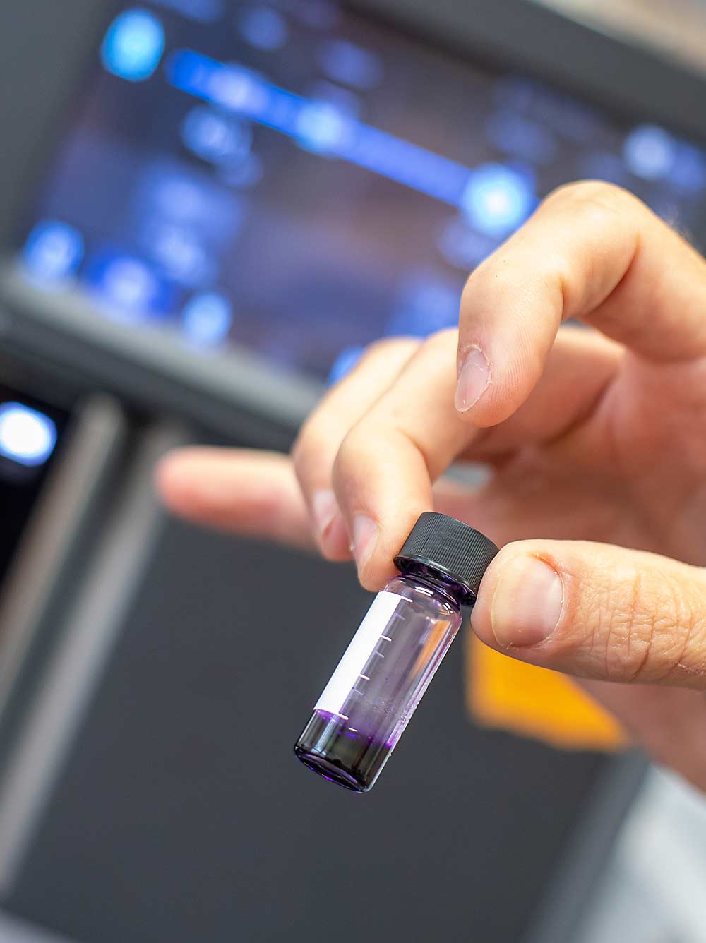 Cerrato holds a small grape juice sample that will be analyzed as part of research to understand why compounds contribute to the perception of smoke taint in some wines. (TJ Mullinax/Good Fruit Grower)