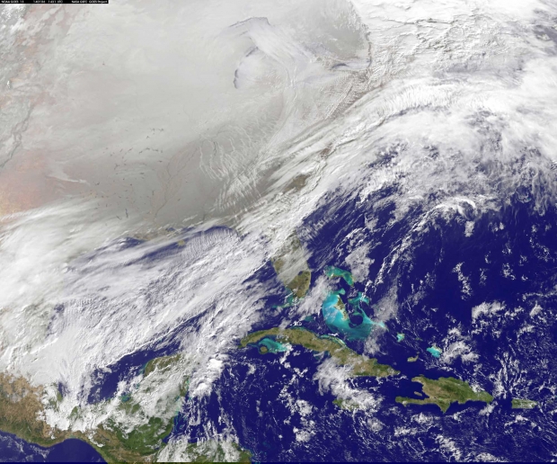 In this satellite image, a frontal system that brought rain to the East Coast in early January is draped from north to south. Behind it lie the clearer skies that brought bitter cold air associated with the polar vortex.  Image captured by NOAA’s GOES East satellite on January 6, 2014.  CLICK TO ENLARGE