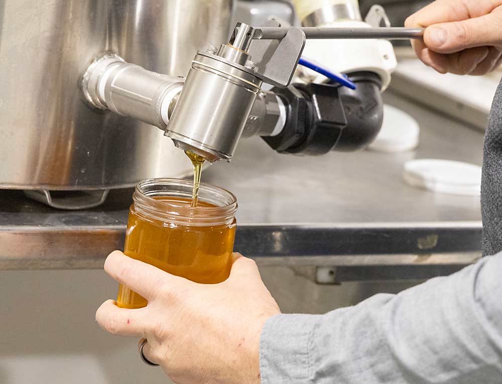 The pollinator center is equipped to make honey from MSU honey bee colonies. Wyns pours some of the finished product, which is often consumed at MSU food service facilities. (Matt Milkovich/Good Fruit Grower)