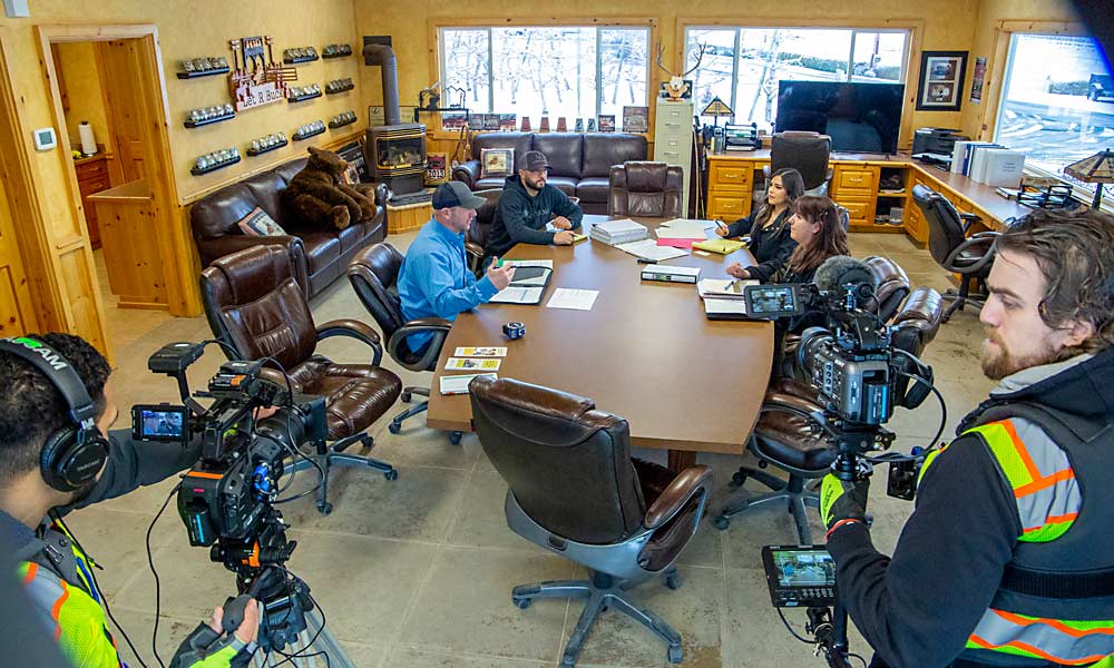 Washington State Department of Labor and Industries consultants and G.S. Long orchard staff re-enact a safety consultation meeting for an L&I video promoting the agency’s voluntary program in February near Naches. The workplace safety agency offers benefits, such as a reprieve from unannounced compliance inspections, to growers who proactively schedule a safety walk-through consultation. Record checking is part of the process. From left are Mitch Reffett of L&I, Eladio Gonzales of G.S. Long, Jessica Capi of G.S. Long and Erica Minton of L&I. (Ross Courtney/Good Fruit Grower)