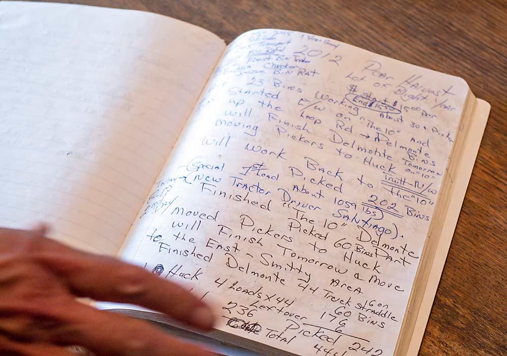 Smith flips through a farm journal at Smith Orchards. These detailed records help Smith operate the farm and make decisions from year to year. (Jonelle Mejica/Good Fruit Grower)