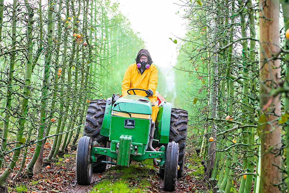 Eddie Kasner, a researcher with the Pacific Northwest Agricultural Safety and Health Center at the University of Washington, drives the tractor during a drift trial conducted with WSU researchers in late fall 2018. Researchers will repeat the same procedure again this summer when the orchard has a full canopy. (TJ Mullinax/Good Fruit Grower)