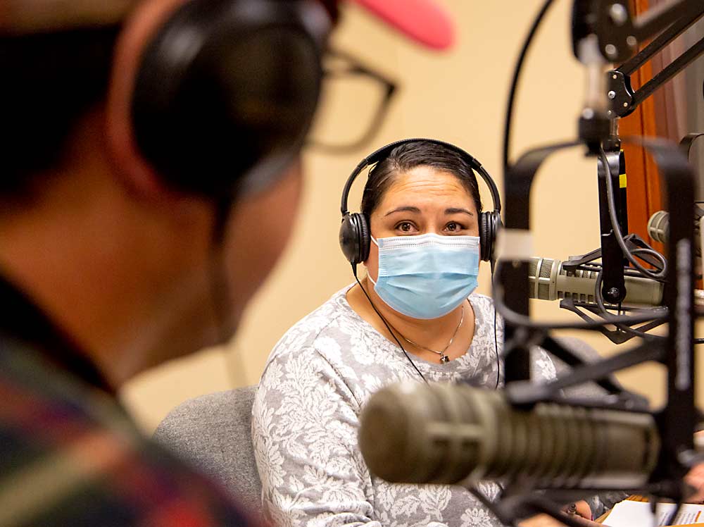 Elizabeth Torres and Francisco Rios of Radio KDNA discuss the importance of vaccines for farmworkers during Aqui y Alla, a weekly program at the Granger, Washington, Spanish-language public radio station. It airs at 4 p.m. every Friday. (Ross Courtney/Good Fruit Grower)