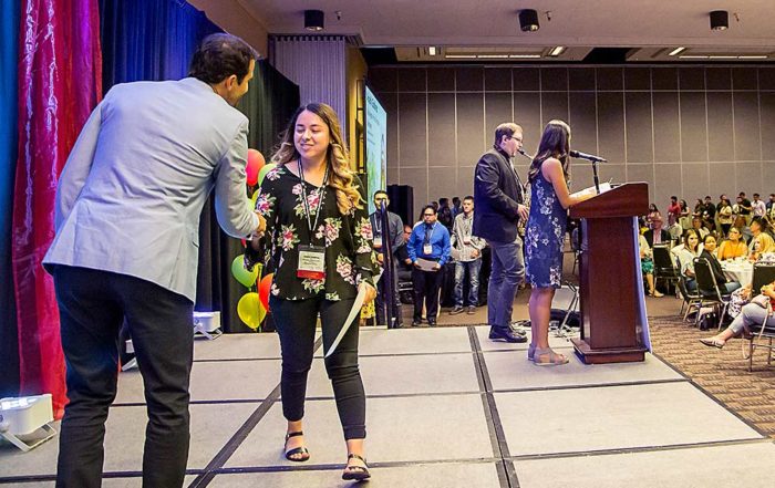 Scholarship recipient Anahi Goninez shakes hands with Chris Willett, WAEF chair, at the organization’s awards luncheon in Yakima in late July. (Ross Courtney/Good Fruit Grower)