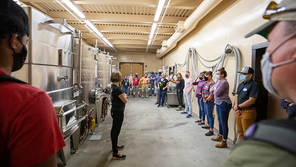 As the interim director of winemaking, Sabrina Lueck, center, in black, gives students a safety briefing in the College Cellars winery. New students hit the ground running with harvest a day after this orientation. (TJ Mullinax/Good Fruit Grower)