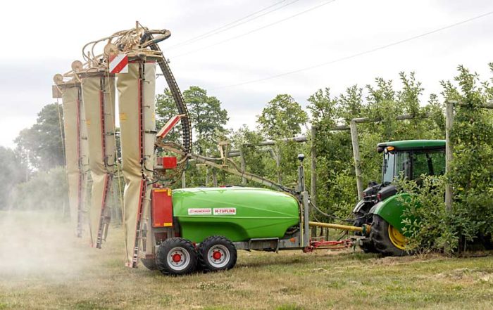 A tractor pulls grower Mike Wittenbach’s Munckhof three-row orchard sprayer through a Gala block in July, during a demonstration. (Matt Milkovich/Good Fruit Grower)