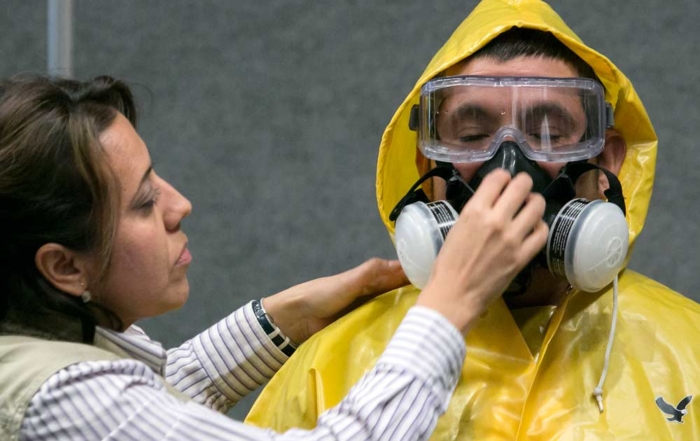Flor Servin of the Washington Department of Labor and Industries demonstrates personal protective equipment use on Adolfo Meza at a pesticide decontamination training in 2015. New federal worker protection standards require annual training for workers and handlers. (TJ Mullinax/Good Fruit Grower)