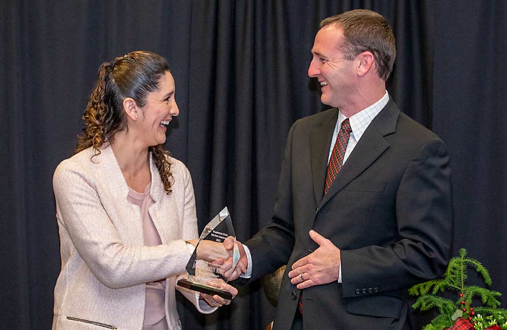 Jacqui Gordon Nuñez, left, is presented with the 2021 Latino Leadership Award by Jordan Matson during the Washington State Tree Fruit Association's awards banquet on Tuesday, Dec. 7, at the Yakima Convention Center in Yakima, Washington. (TJ Mullinax/Good Fruit Grower)