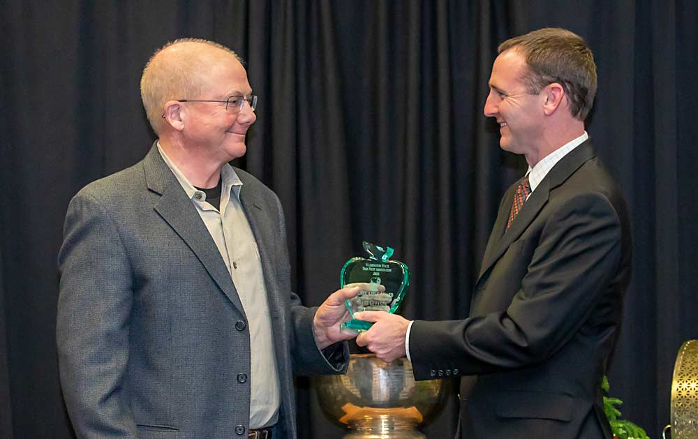 Dave Gleason, left, is presented with the 2021 Silver Apple Award by Jordan Matson. (TJ Mullinax/Good Fruit Grower)