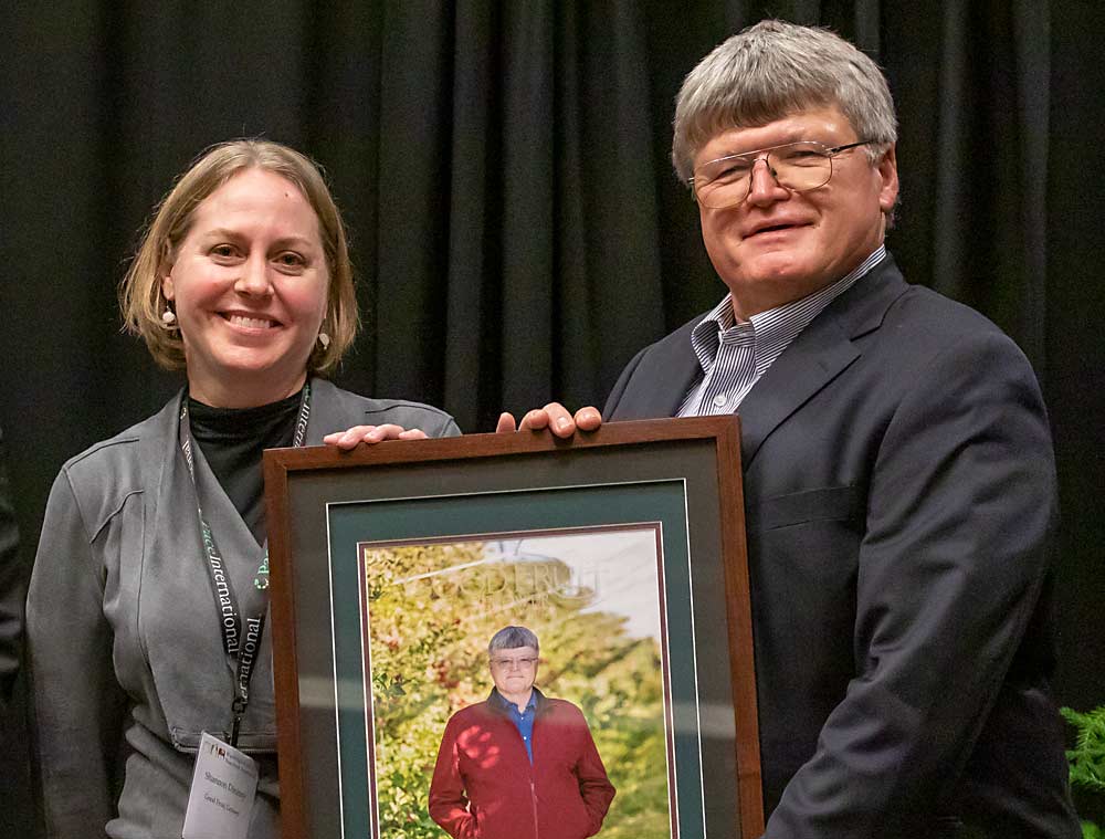 Shannon Dininny, left, presents the Good Fruit Grower of the Year Award to Mike Robinson. (TJ Mullinax/Good Fruit Grower)