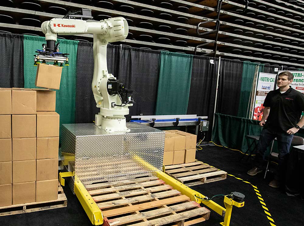 A Beyond The Box Solutions automated palletizing robot demonstration is one of several displays during the first day of the Washington State Tree Fruit Association's NW Hort Expo on Monday, December 6, 2021 at the Yakima Valley SunDome in Yakima, Washington. (TJ Mullinax/Good Fruit Grower)
