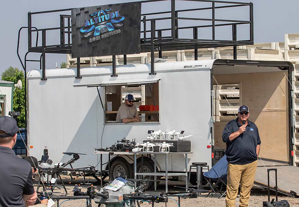 Kurt Beckley of Altitude Agri Services, based in Richland, Washington, is flanked by the equipment that drones require, shown outside his trailer. (TJ Mullinax/Good Fruit Grower)